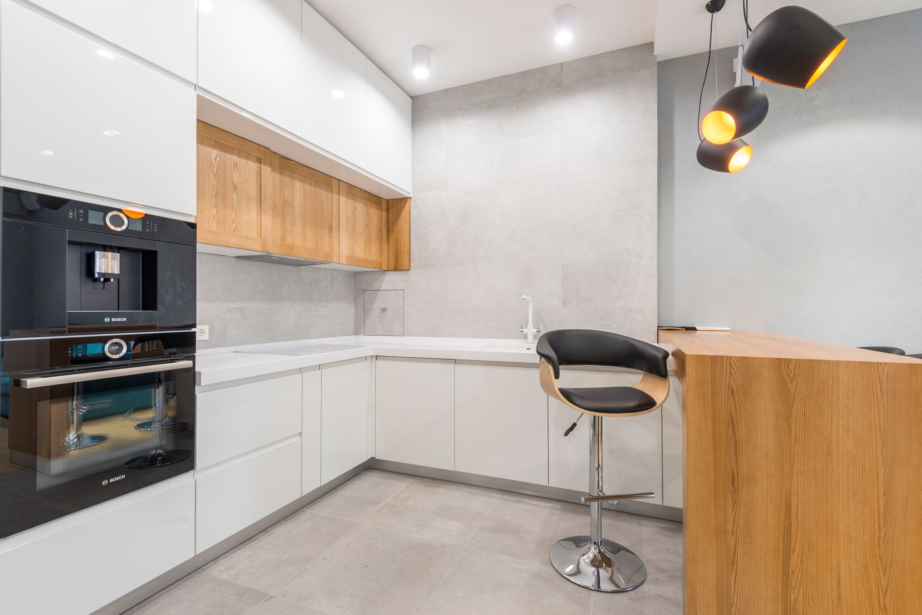 Interior of modern spacious kitchen with wooden furniture and oven and with many lamps in Palm Springs, CA